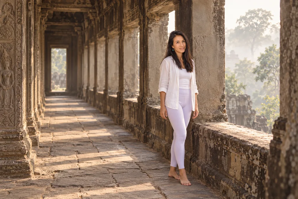 Marielisa Padilla walking a stone temple gallery at dawn, mist in the trees beyond